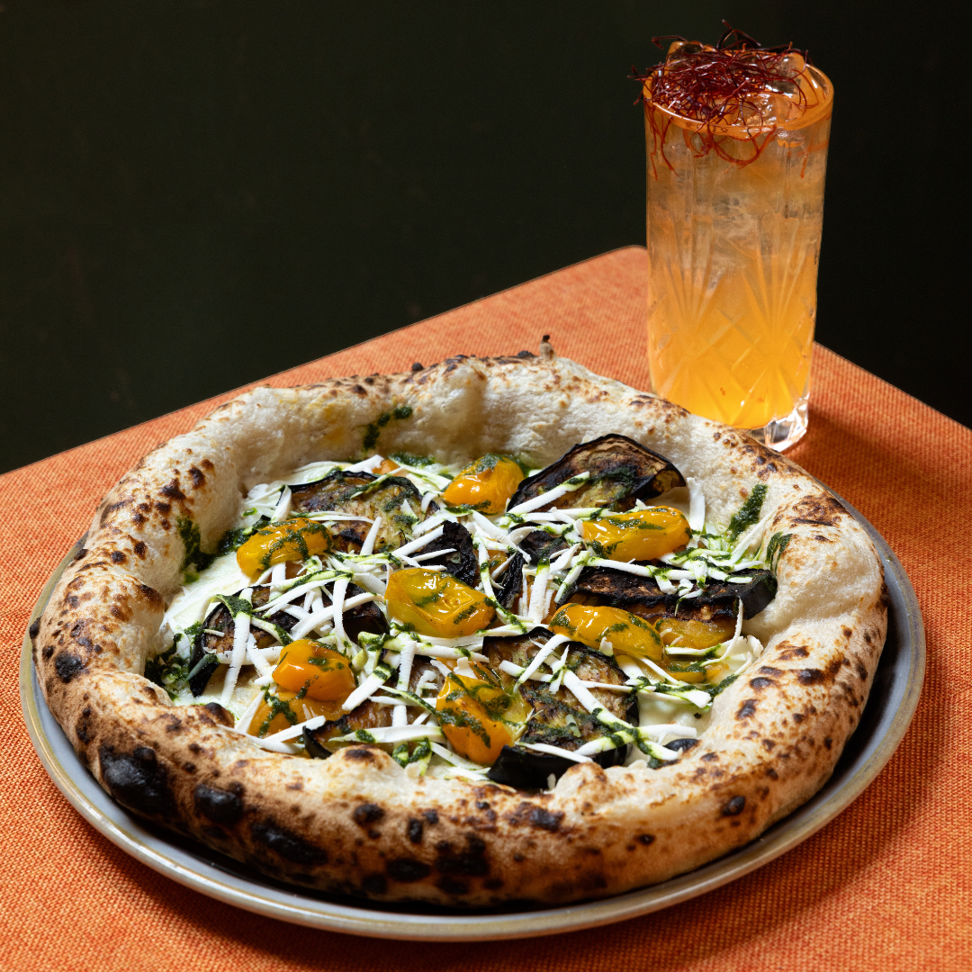 Migliore pizza contemporanea a Bologna è la pizza con datterini gialli scaglie di ricotta salata e melanzane e cocktail abbinato