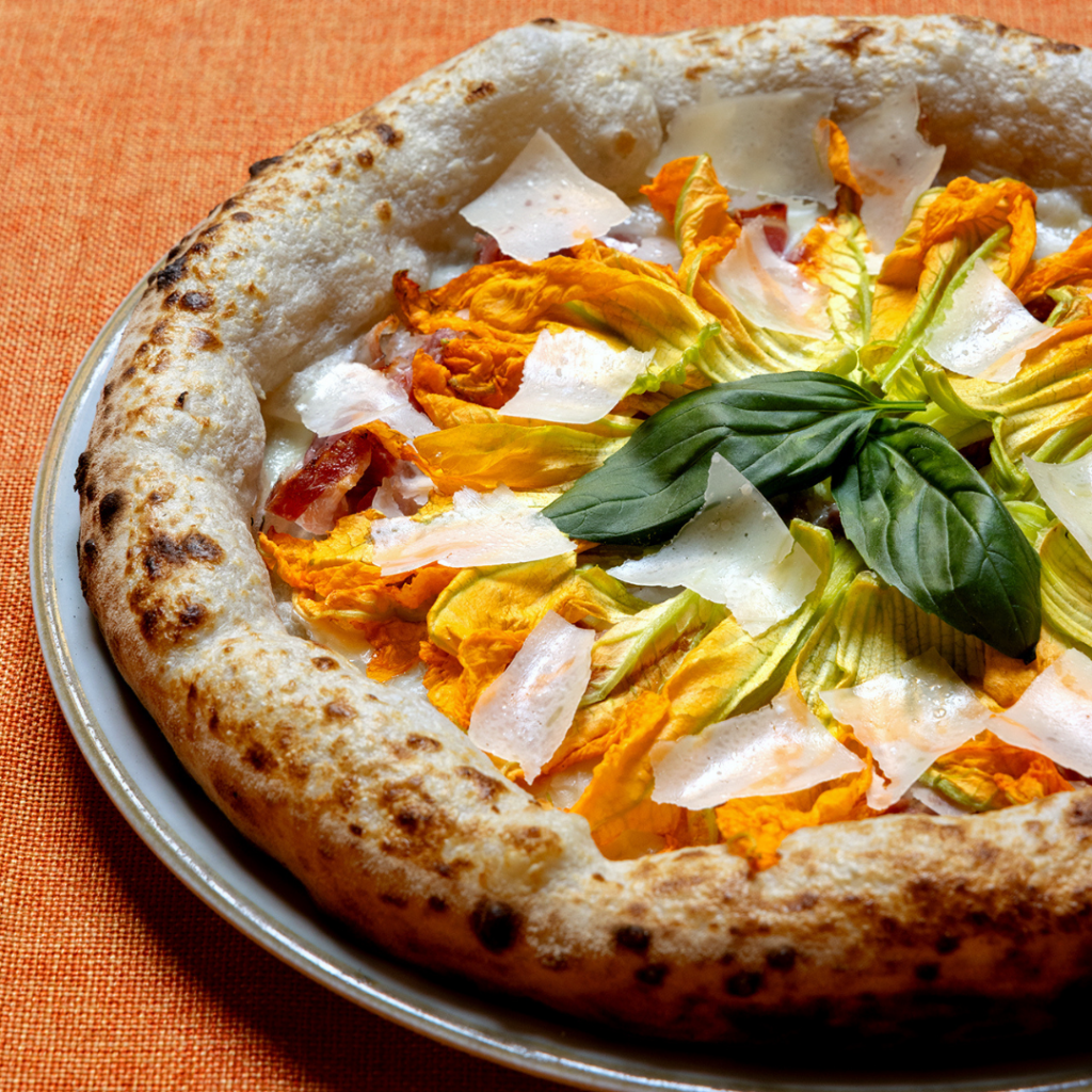 Migliore pizza contemporanea a Bologna è con fiori di zucca in uscita e scaglie di parmigiano