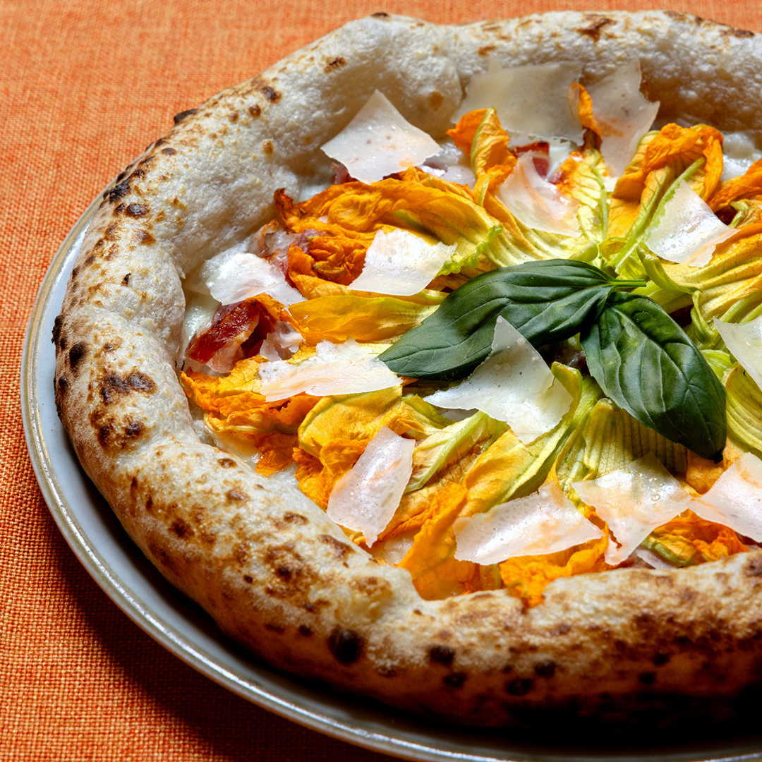 Migliore pizza contemporanea a Bologna è con fiori di zucca in uscita e scaglie di parmigiano