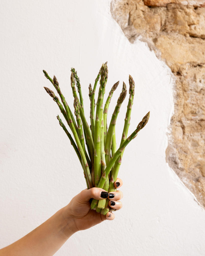 mazzo di asparagi in una mano come fossero fiori della migliore pizza in centro a Bologna